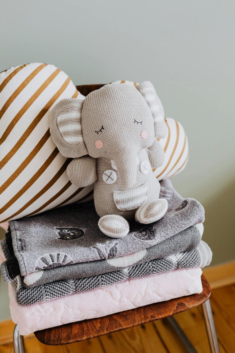 Charming baby room decor featuring a plush elephant toy and cozy textiles.
